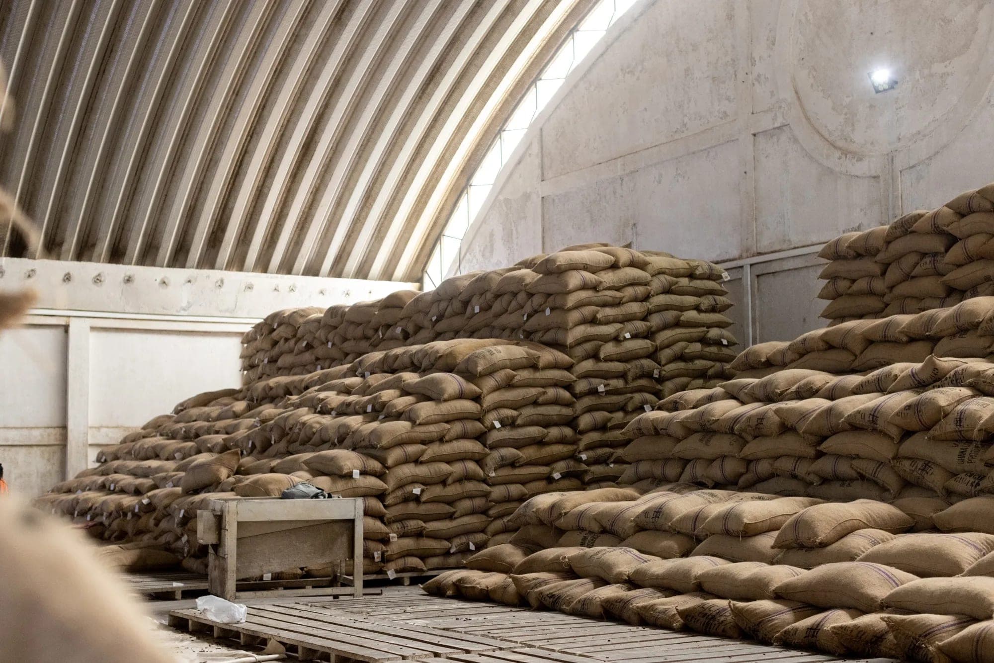 Jute sacks of cocoa stacked inside a storage warehouse